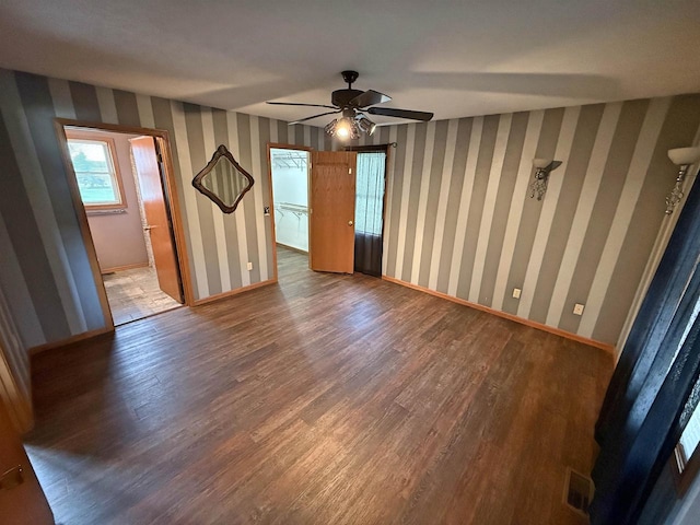 unfurnished room with baseboards, a ceiling fan, wood finished floors, and wallpapered walls
