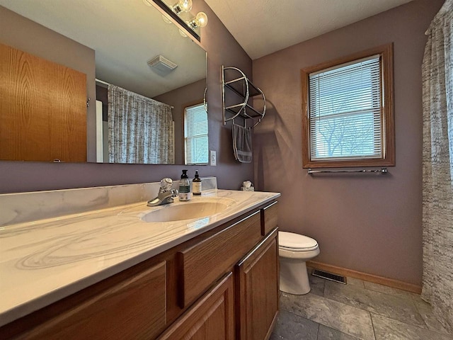full bathroom featuring toilet, visible vents, a wealth of natural light, and vanity