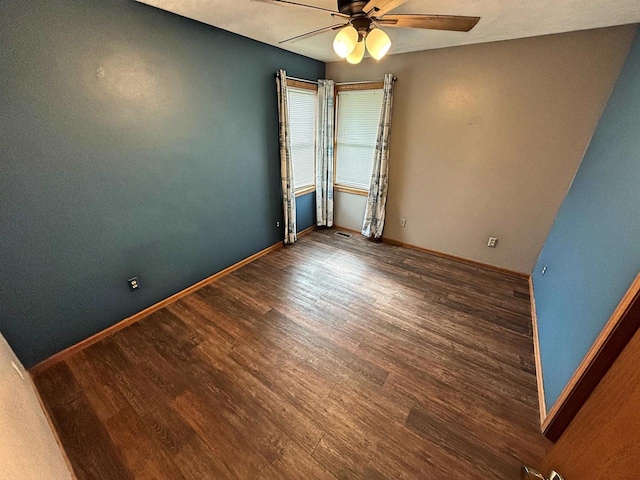 spare room featuring a ceiling fan, baseboards, visible vents, and wood finished floors