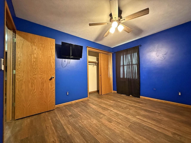 unfurnished bedroom featuring a textured ceiling, a ceiling fan, baseboards, wood finished floors, and a closet