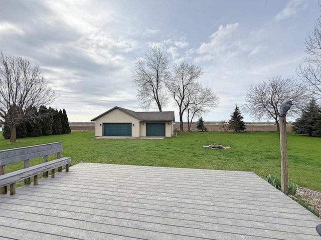 deck featuring a lawn, an outbuilding, and a garage