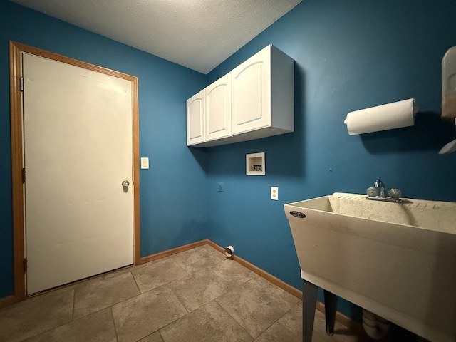 laundry room featuring baseboards, hookup for a washing machine, a textured ceiling, a sink, and cabinet space