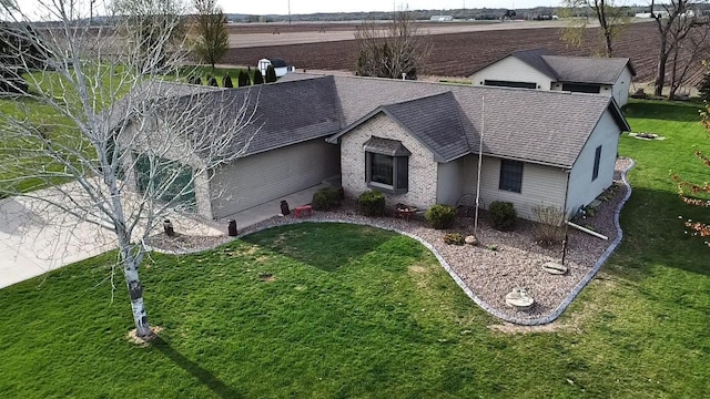 view of front of house featuring roof with shingles and a front yard