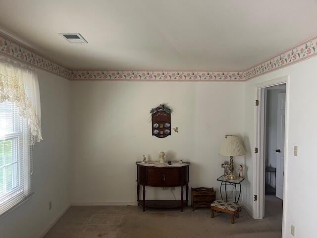 empty room featuring baseboards, visible vents, and light carpet
