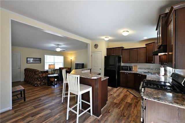 13585 Oswald Rd, Drummond, WI 54832 - kitchen featuring dark brown cabinets, black appliances, open floor plan, ornamental molding, and under cabinet range hood
