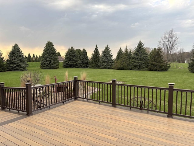 deck at dusk featuring a lawn