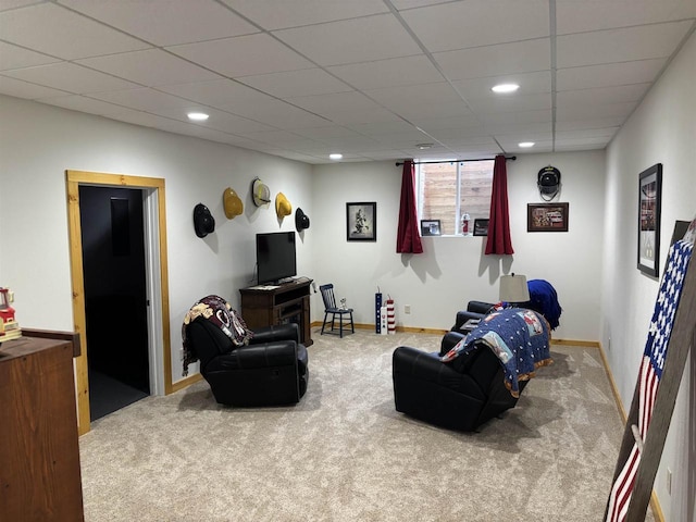 living area featuring carpet floors, baseboards, recessed lighting, and a paneled ceiling