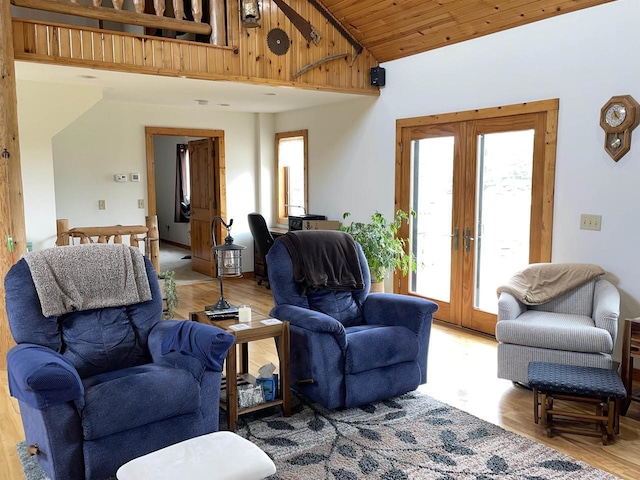 living room featuring french doors, light wood-style floors, and high vaulted ceiling