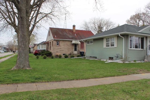 436 Roosevelt St, Fond Du Lac, WI 54935 - view of front of home featuring a chimney, a front yard, and roof with shingles