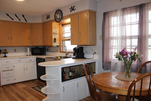 436 Roosevelt St, Fond Du Lac, WI 54935 - kitchen with open shelves, a sink, wood finished floors, light countertops, and black appliances