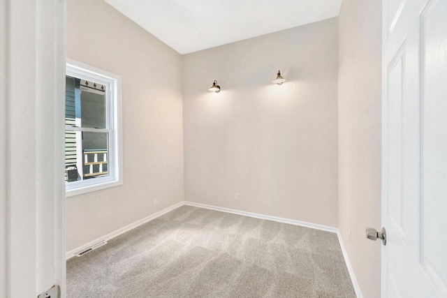 carpeted empty room featuring baseboards and visible vents