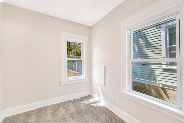 carpeted empty room with visible vents and baseboards
