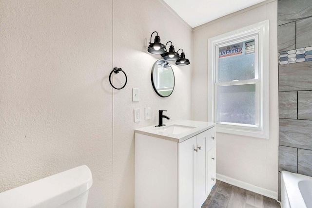 full bath with toilet, plenty of natural light, wood finished floors, and vanity