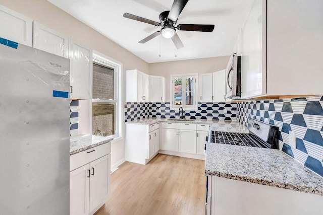 kitchen featuring a sink, tasteful backsplash, a ceiling fan, and stainless steel appliances