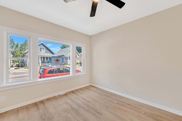 empty room with baseboards, light wood finished floors, and visible vents