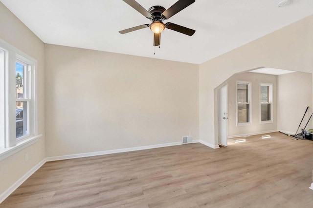 spare room featuring a ceiling fan, baseboards, visible vents, and light wood-style floors