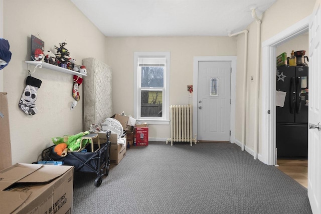 interior space with carpet floors, baseboards, and radiator