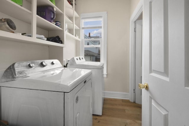 laundry area featuring laundry area, light wood-style flooring, baseboards, and washing machine and clothes dryer