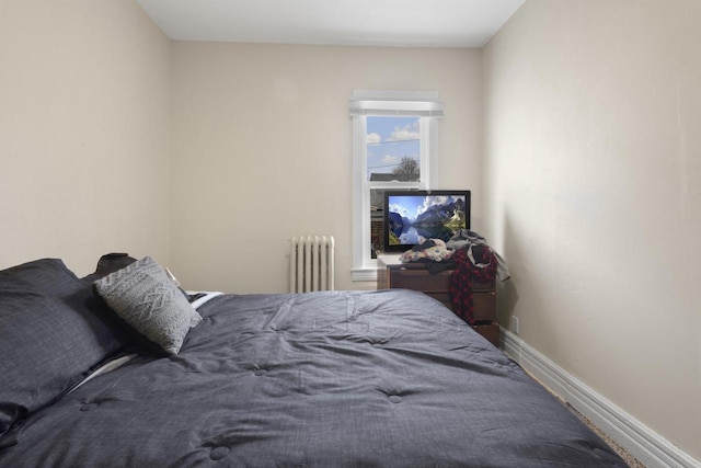 bedroom featuring baseboards and radiator heating unit