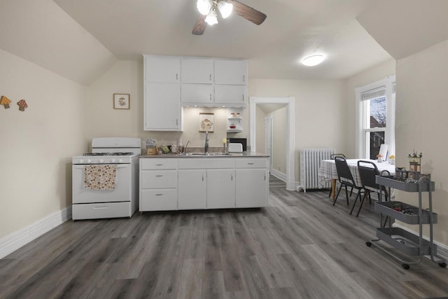 kitchen featuring a sink, radiator, white gas range oven, and baseboards