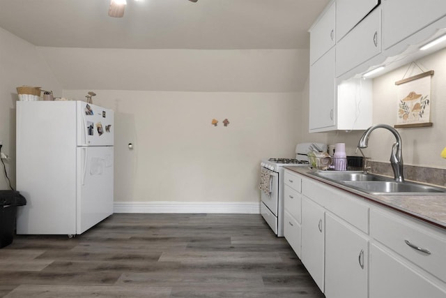 kitchen featuring lofted ceiling, white appliances, baseboards, white cabinets, and a sink