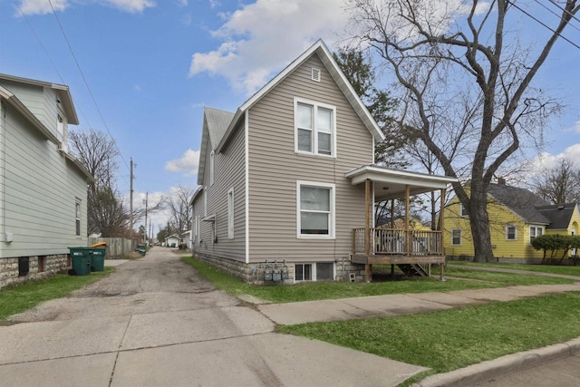 view of property exterior featuring a lawn, driveway, and a porch