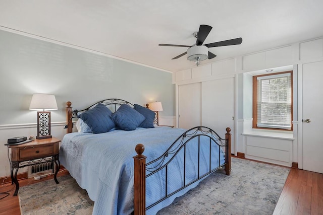 1517 Torrison Dr, Manitowoc, WI 54220 - bedroom with a decorative wall, wood finished floors, a closet, and ceiling fan