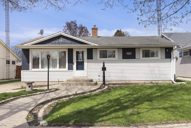 view of front of property featuring a chimney, a shingled roof, and a front yard
