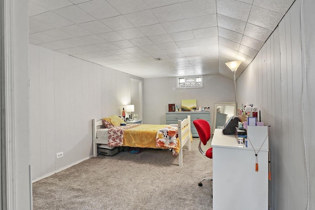 bedroom with carpet floors and wood walls