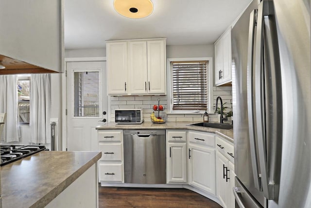 kitchen with a sink, decorative backsplash, appliances with stainless steel finishes, and a wealth of natural light