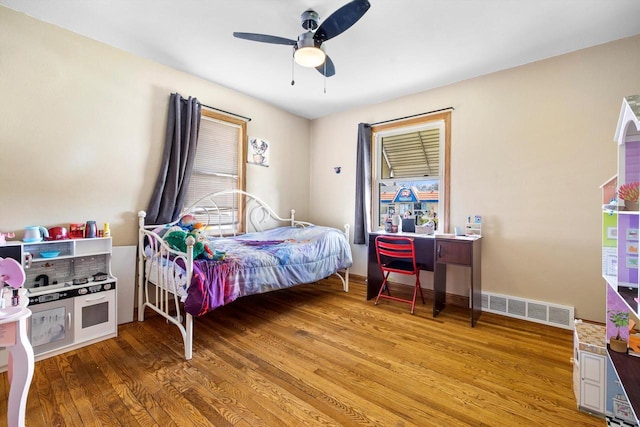 bedroom featuring visible vents, ceiling fan, multiple windows, and light wood-type flooring