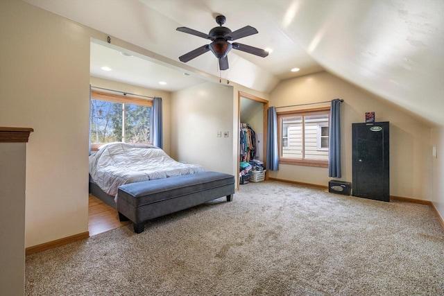 carpeted bedroom featuring baseboards, multiple windows, and vaulted ceiling