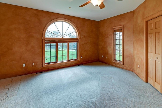 457 Union Rd, Brooklyn, WI 53521 - carpeted empty room featuring visible vents, baseboards, ceiling fan, and a healthy amount of sunlight