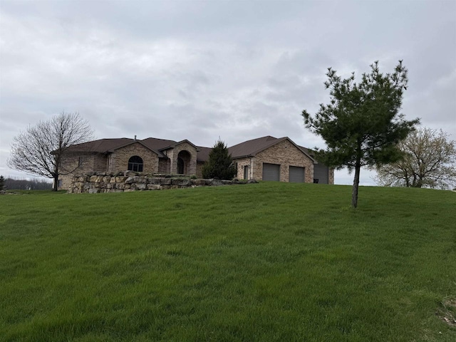 457 Union Rd, Brooklyn, WI 53521 - view of front facade featuring an attached garage, stone siding, and a front lawn