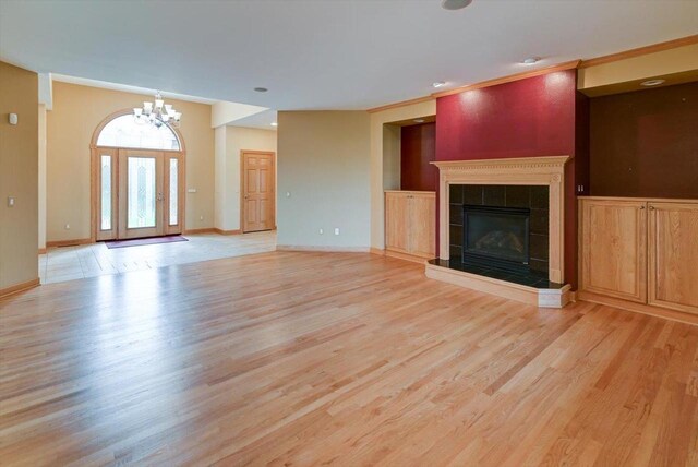 457 Union Rd, Brooklyn, WI 53521 - unfurnished living room featuring an inviting chandelier, baseboards, a tiled fireplace, and light wood-type flooring