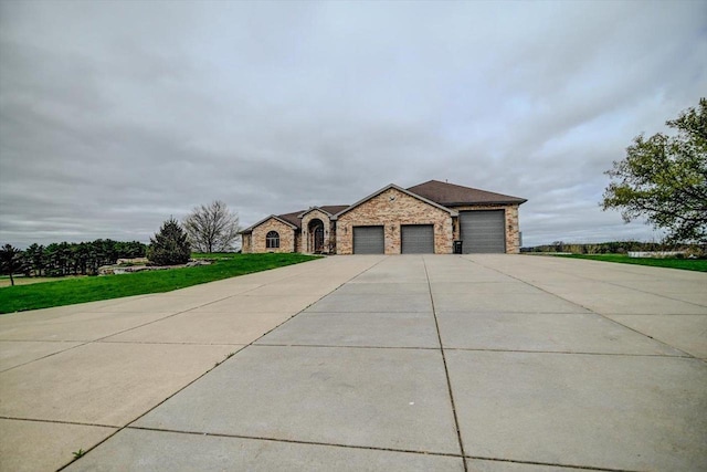 457 Union Rd, Brooklyn, WI 53521 - view of front of house with stone siding, an attached garage, driveway, and a front yard