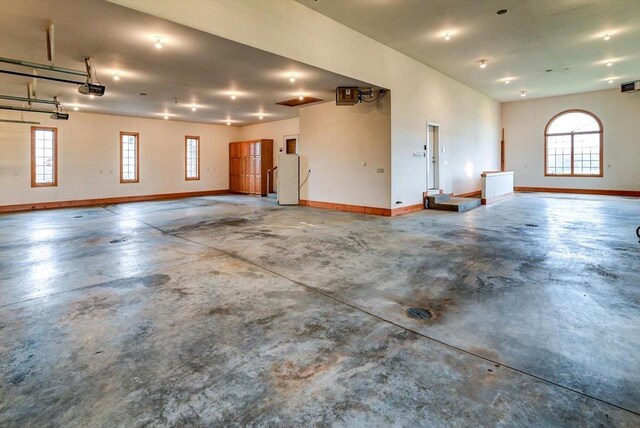 457 Union Rd, Brooklyn, WI 53521 - garage with baseboards, freestanding refrigerator, a garage door opener, and visible vents