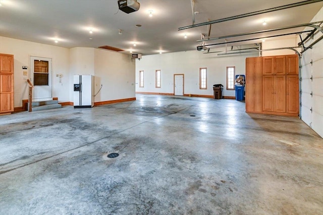 457 Union Rd, Brooklyn, WI 53521 - garage with baseboards, a garage door opener, and white fridge with ice dispenser