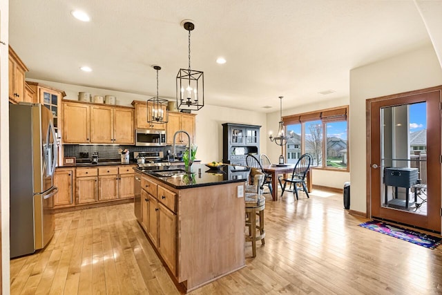 3500 Sequoia Cir, Waukesha, WI 53188 - kitchen with dark countertops, a sink, a chandelier, stainless steel appliances, and a kitchen bar