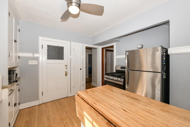 kitchen featuring butcher block counters, ceiling fan, white cabinetry, light wood-style flooring, and stainless steel appliances
