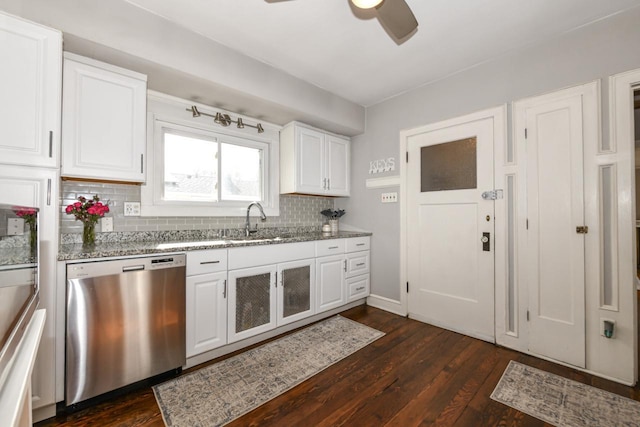kitchen featuring stainless steel dishwasher, a ceiling fan, white cabinets, a sink, and backsplash