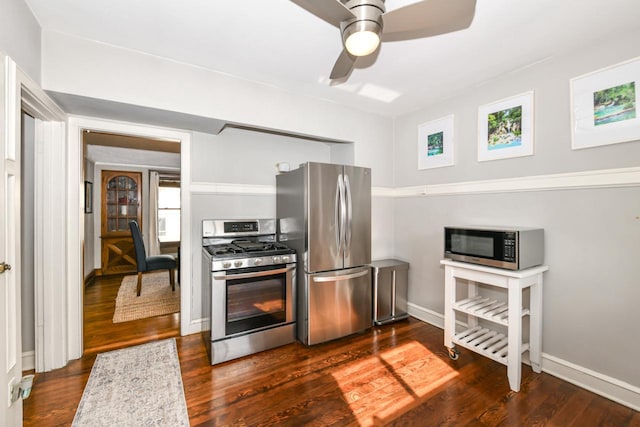 kitchen with a ceiling fan, baseboards, appliances with stainless steel finishes, and dark wood-type flooring