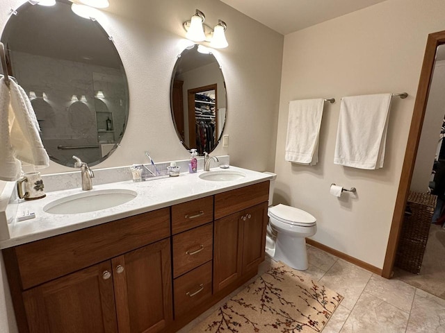 bathroom featuring double vanity, a sink, walk in shower, and a spacious closet