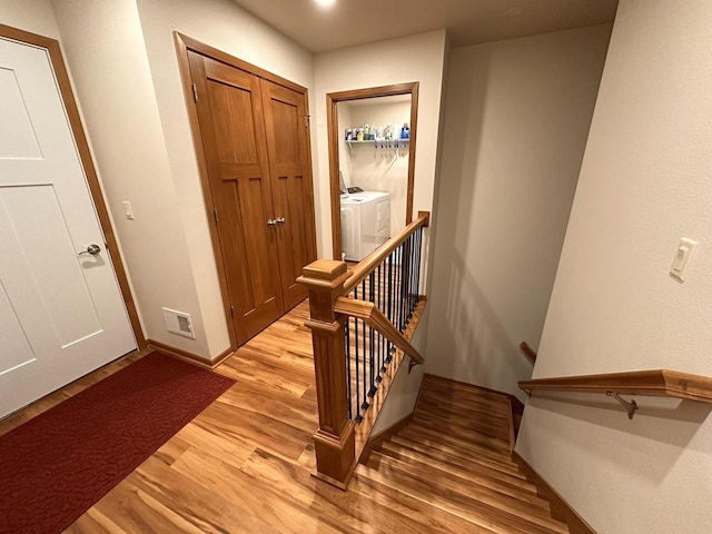 interior space featuring baseboards, visible vents, washing machine and dryer, and light wood-style flooring