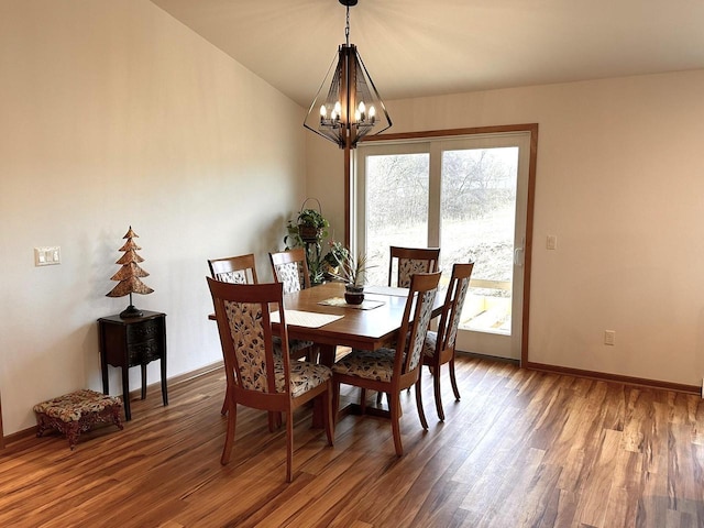 dining room with a healthy amount of sunlight, wood finished floors, and a chandelier