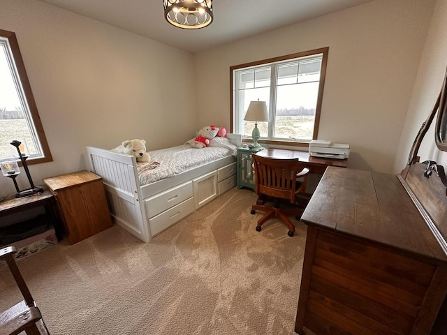bedroom with light colored carpet and a notable chandelier