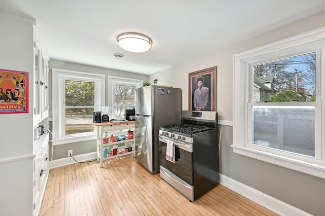 kitchen featuring baseboards, light wood-style flooring, and stainless steel appliances