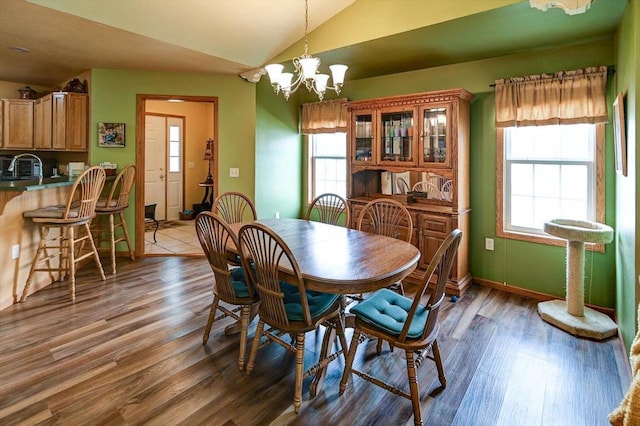 dining room featuring dark wood-style floors, vaulted ceiling, and a healthy amount of sunlight