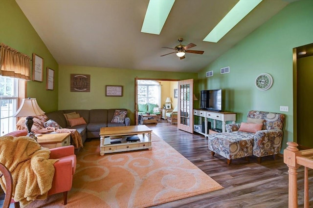 living area with a skylight, a ceiling fan, wood finished floors, and visible vents