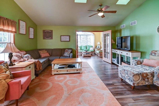 living room featuring visible vents, ceiling fan, wood finished floors, and vaulted ceiling